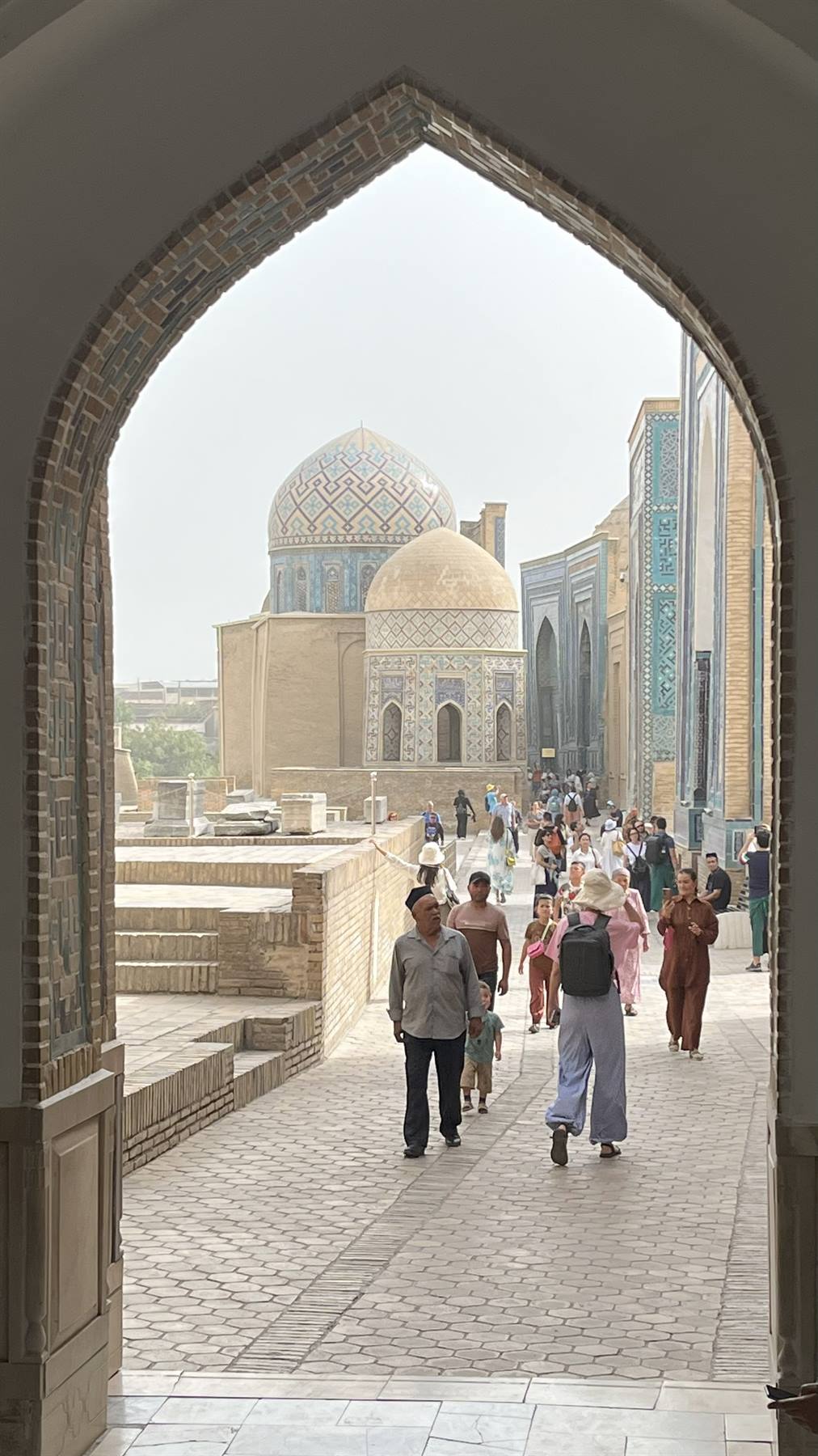 Visitatori lungo il viale delle tombe in mattoni e maioliche di Shah-i-Zinda, Samarcanda