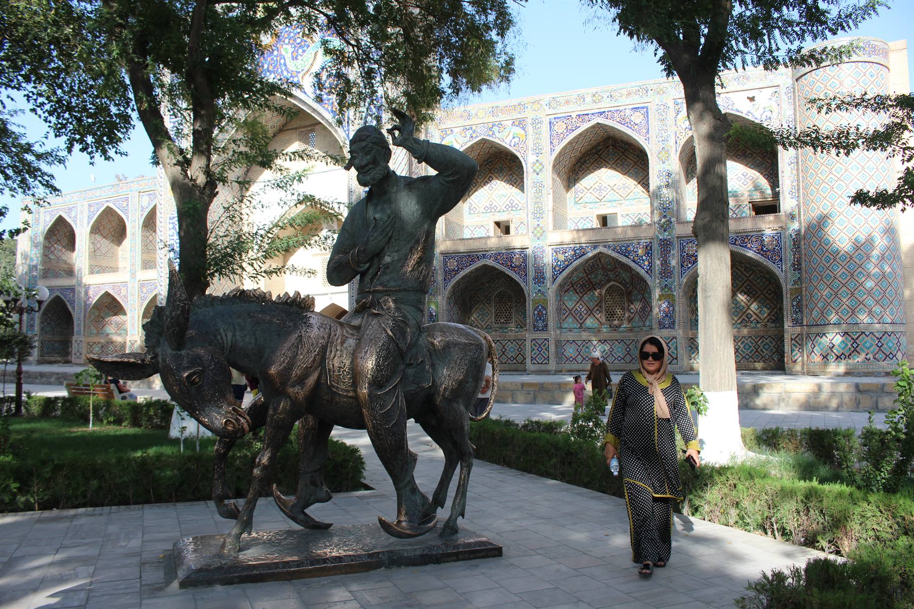 Statua in bronzo di Nasreddin a cavallo dell'asino a Bukhara, davanti alla madrasa