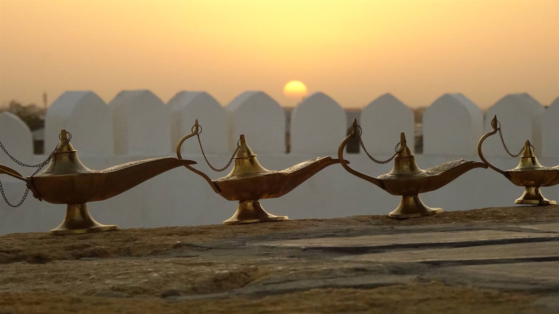 Lampade di ottone allineate sulle mura di Khiva al sorgere del sole