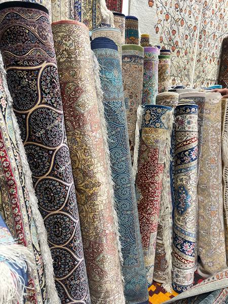 Tappeti arrotolati dai motivi intrecciati nel bazar di Bukhara