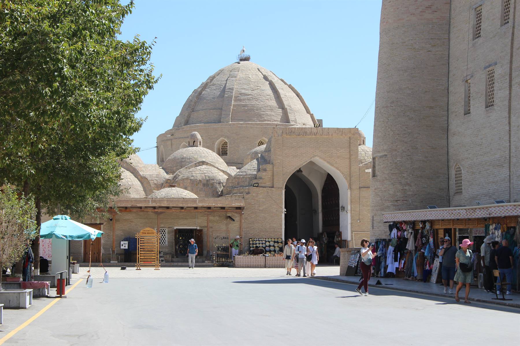 Turisti sotto le cupole in mattoni del bazar coperto di Bukhara