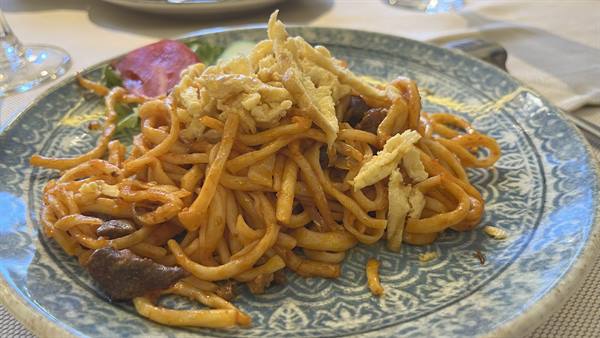 Piatti di noodles fritti con uova su piatto ceramico blu a Tashkent