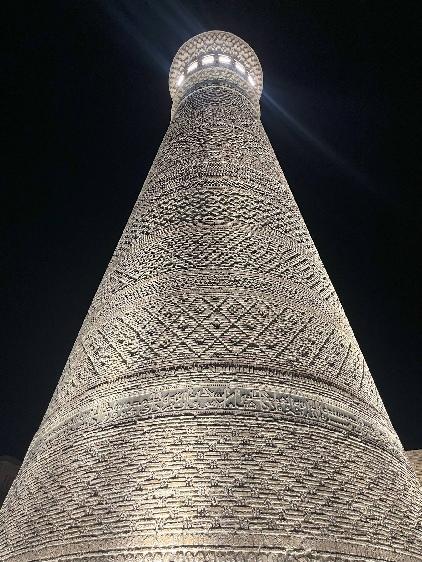 Il minareto Islam Khoja di Khiva, mattoni decorati illuminati nella notte