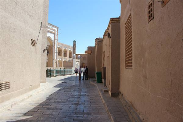Vicolo tra muri di argilla, turisti verso un mausoleo, Khiva