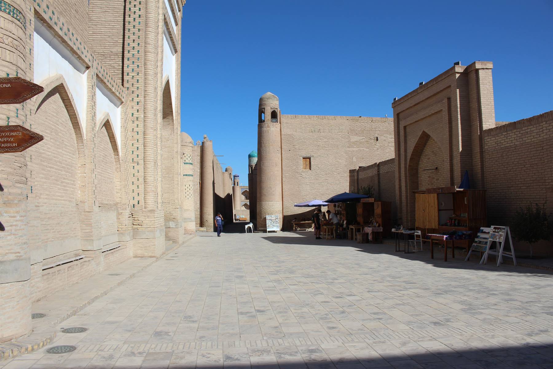 Via lastricata tra madrase in mattoni sotto il cielo azzurro di Khiva