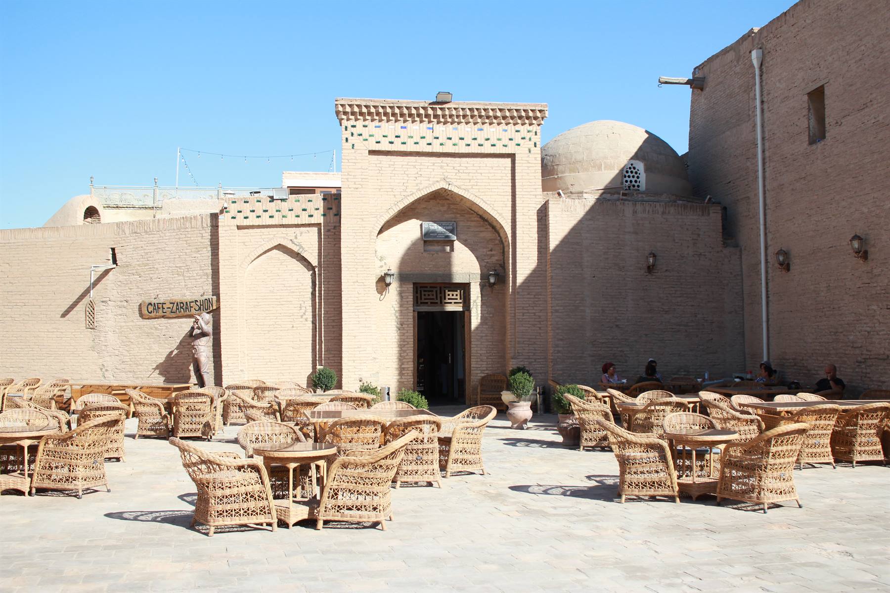 Tavoli di vimini davanti al caffè nella vecchia Khiva, luce intensa