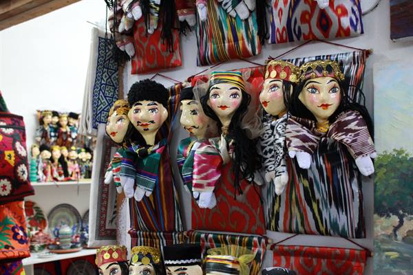 Bambole tradizionali in tessuto ikat appese in un negozio di artigianato a Bukhara