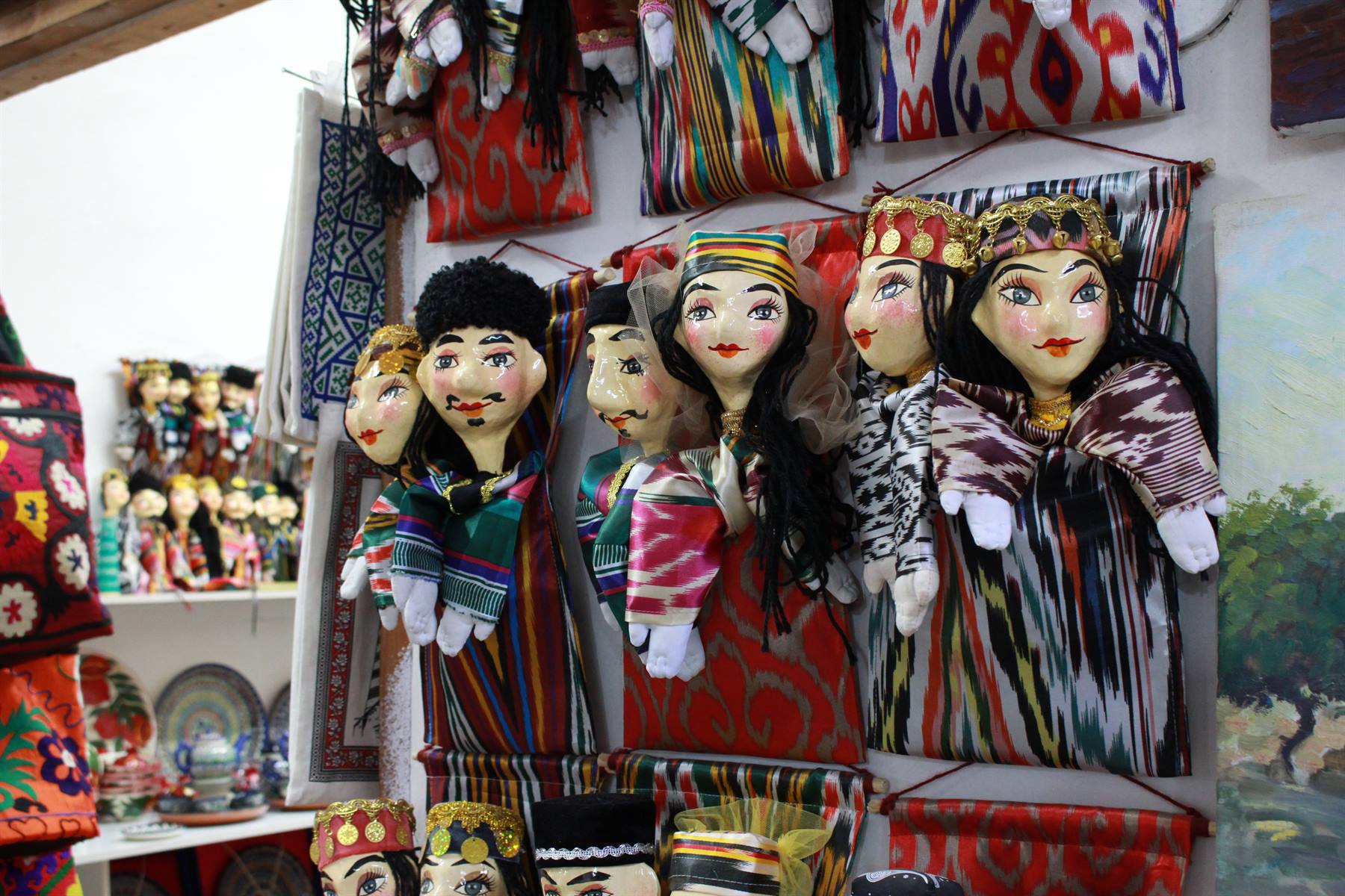 Bambole tradizionali in tessuto ikat appese in un negozio di artigianato a Bukhara