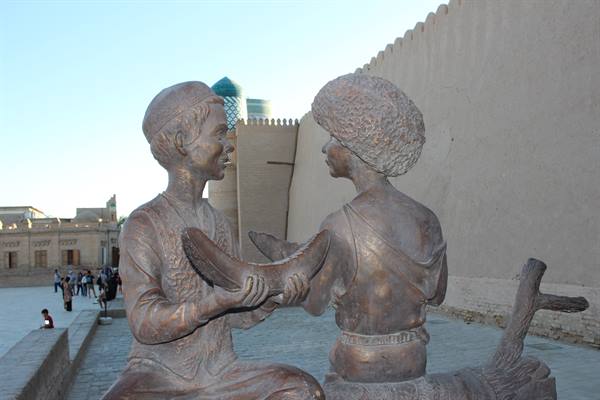 Statua in bronzo di due giovani con melone lungo le mura di Khiva