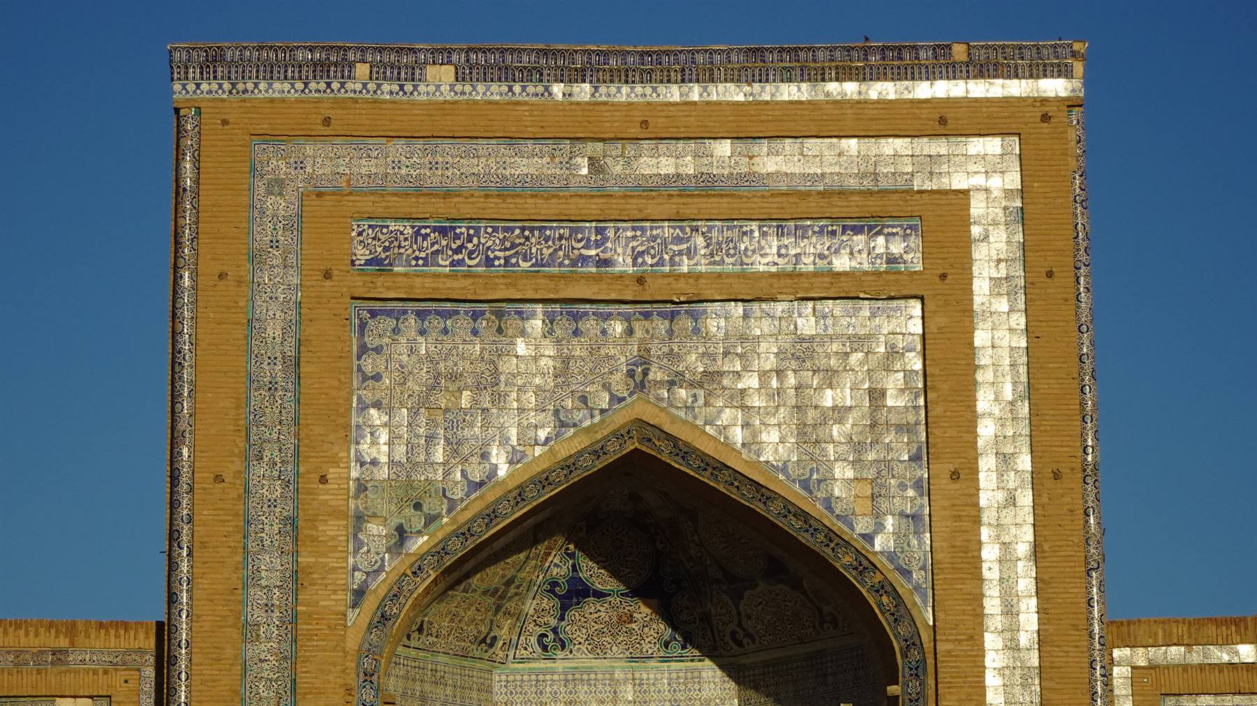 Portale in maiolica blu e oro sotto il cielo terso di Samarcanda