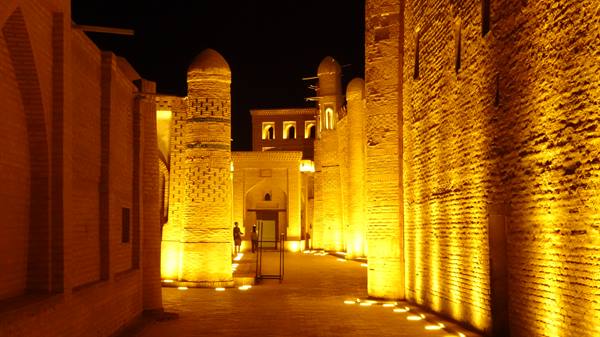 Muri di mattoni illuminati di notte tra le madrase di Khiva
