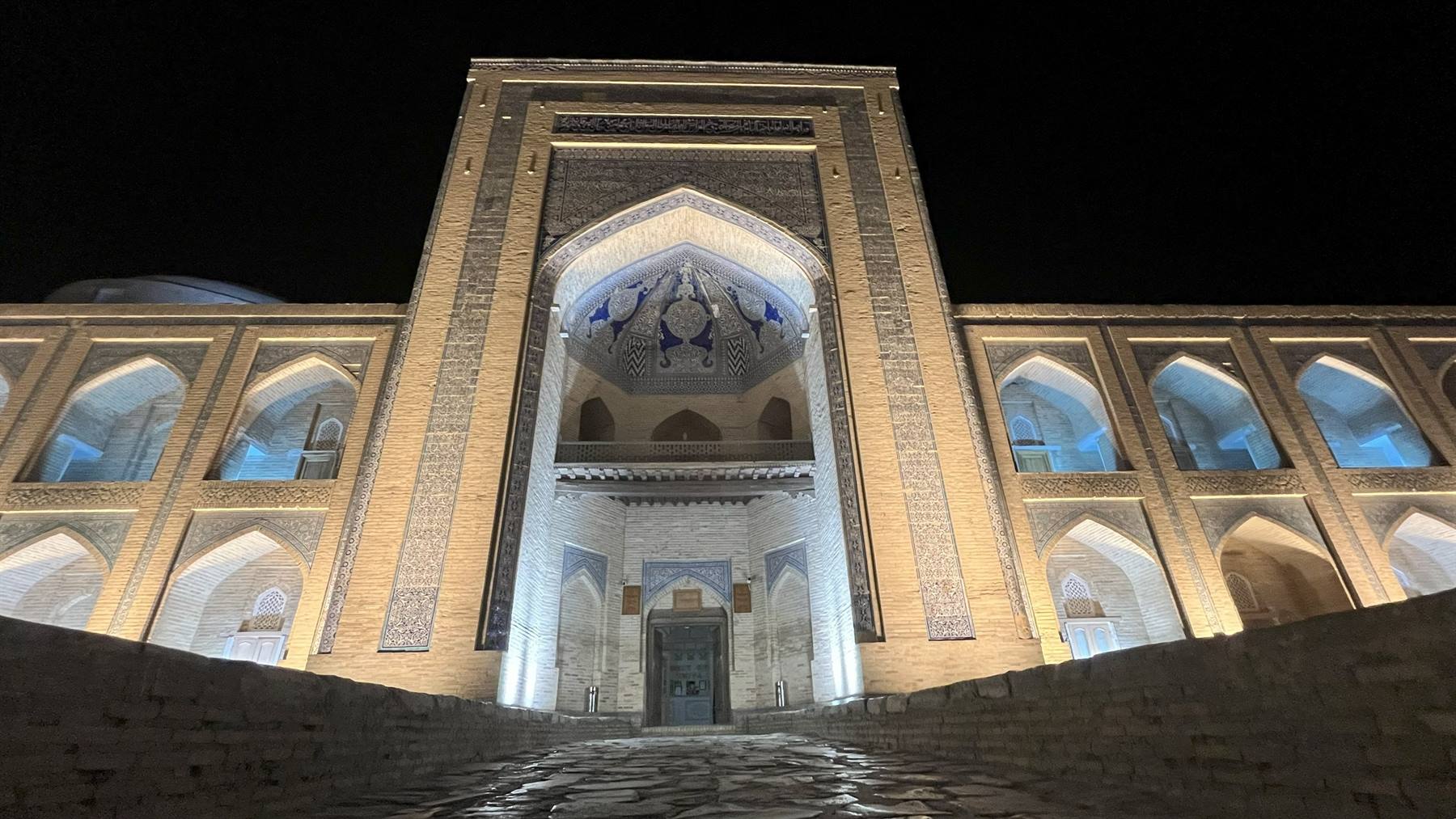 Madrasa in mattoni illuminata di notte, cupola maiolicata blu, Bukhara