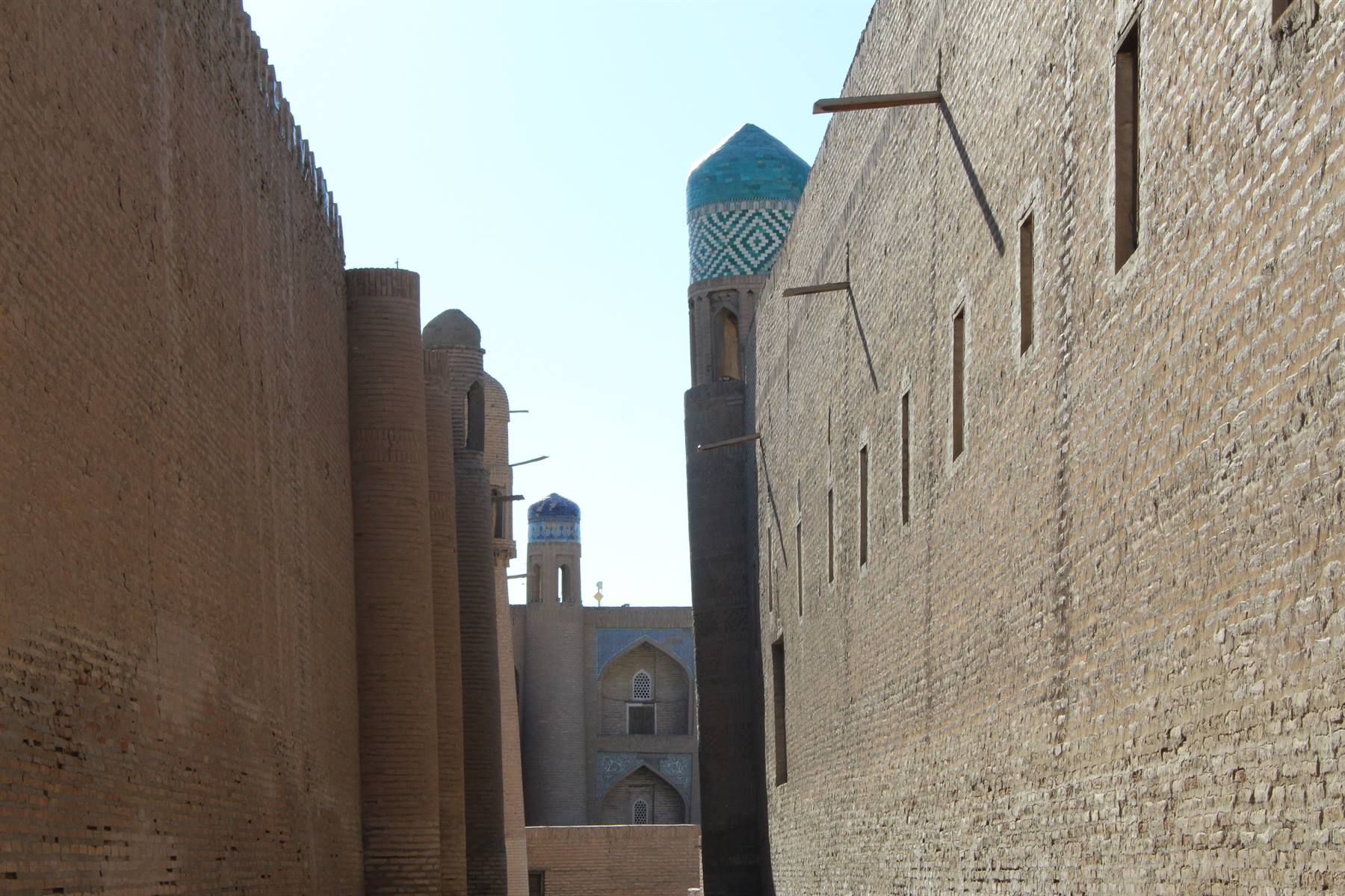 Mura di mattoni di Khiva con minareto decorato a maioliche turchesi