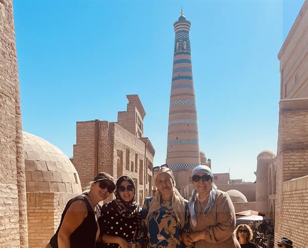 Quattro viaggiatrici sorridono davanti al minareto di Islam Khoja, a Khiva