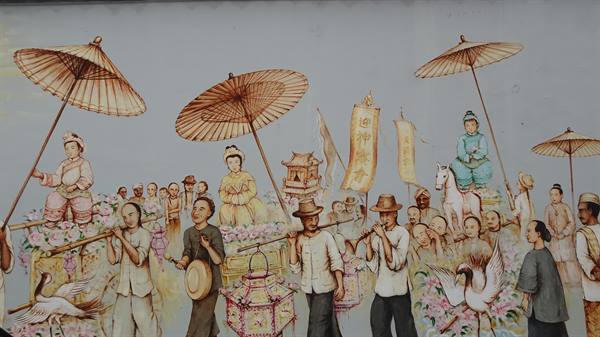 Painted mural with paper umbrellas, musicians and bearers in traditional procession