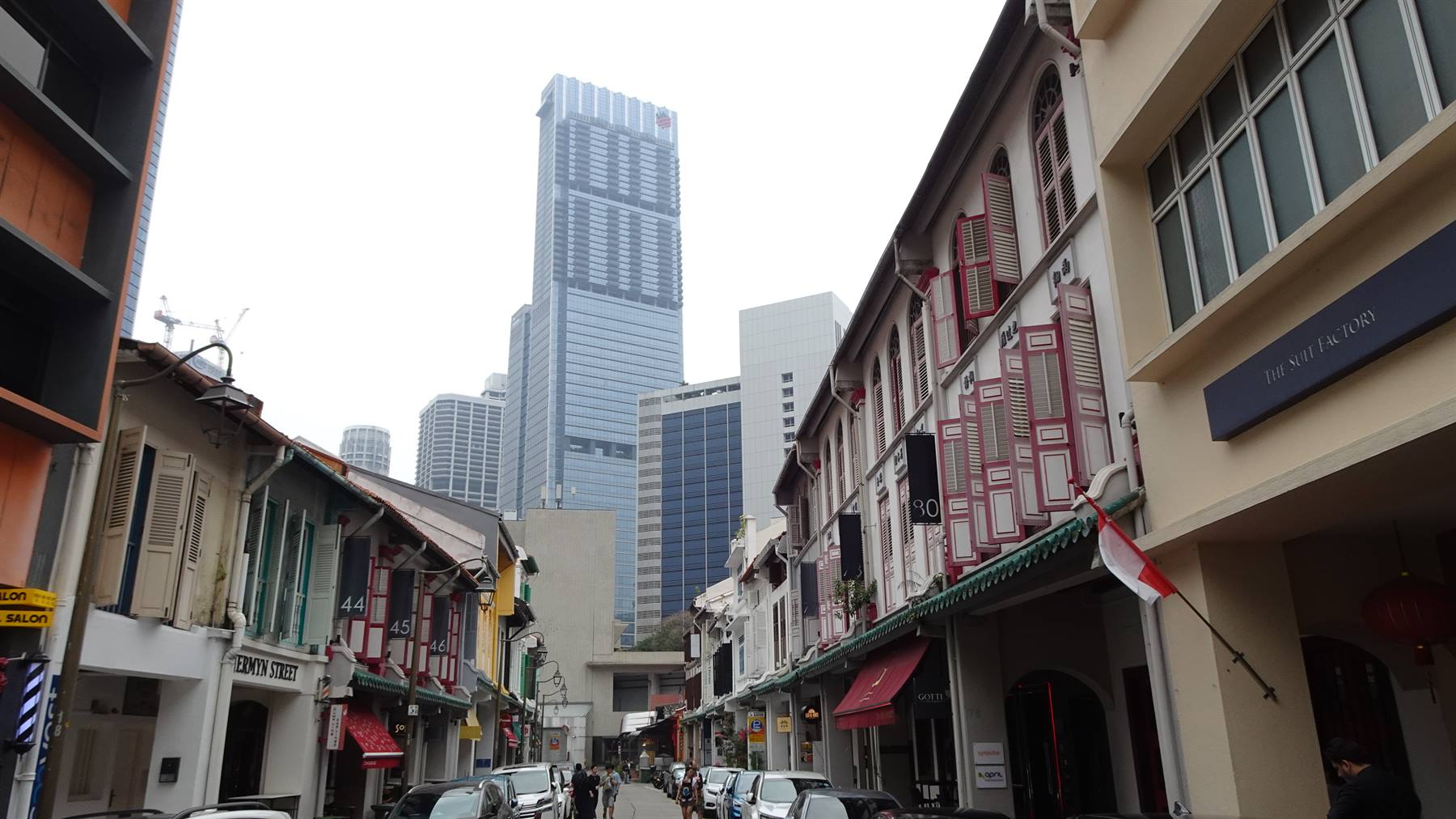 Case a schiera coloniali tra i grattacieli di Chinatown, Singapore, con bandiera rossa e bianca