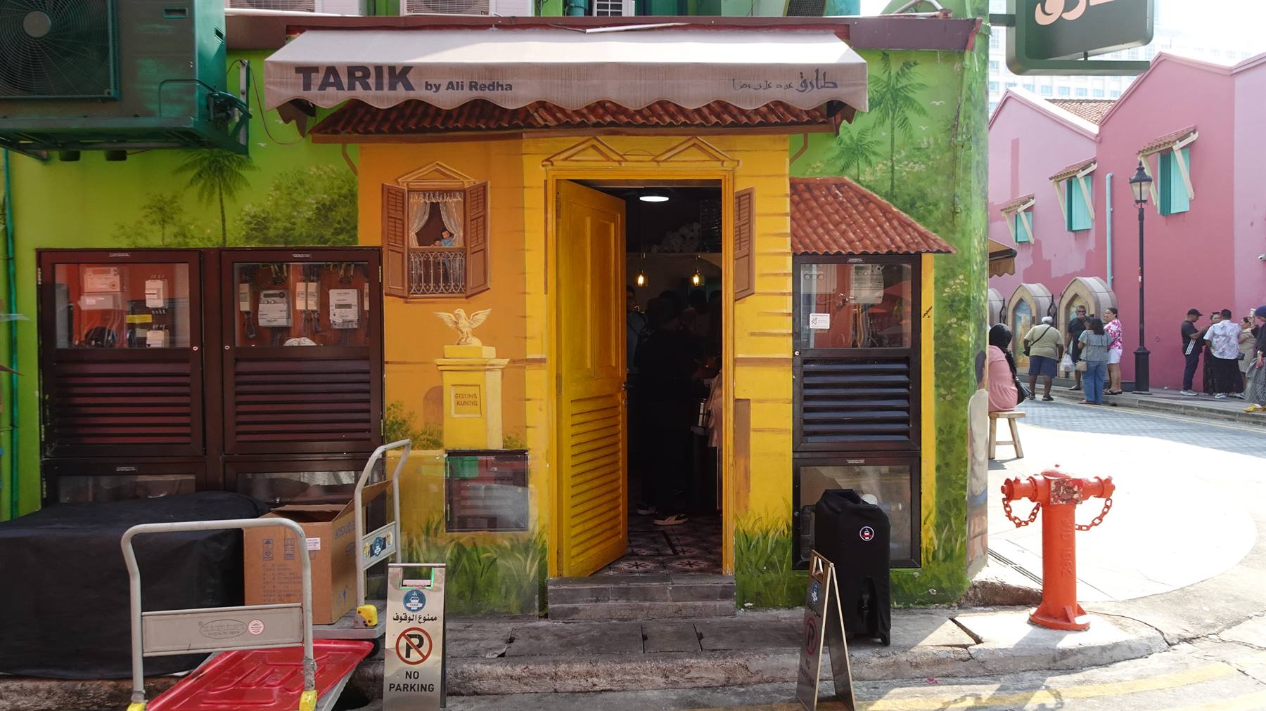 Negozio Tarik con facciata gialla dipinta, idrante rosso e case colorate a Kampong Glam