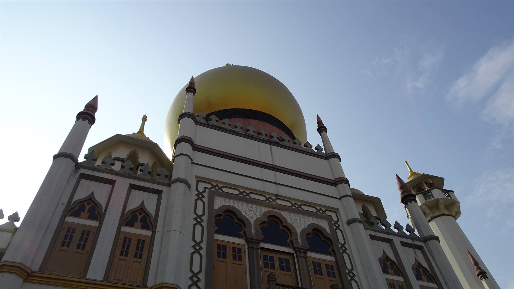 Cupola dorata della Moschea del Sultano a Singapore tra guglie bianche e cielo azzurro