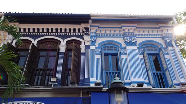 Ornate blue and white striped shophouse facades with wooden shutters, Singapore