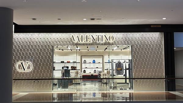 A glowing shop window, gazes full of dreams: Milan welcomes us.