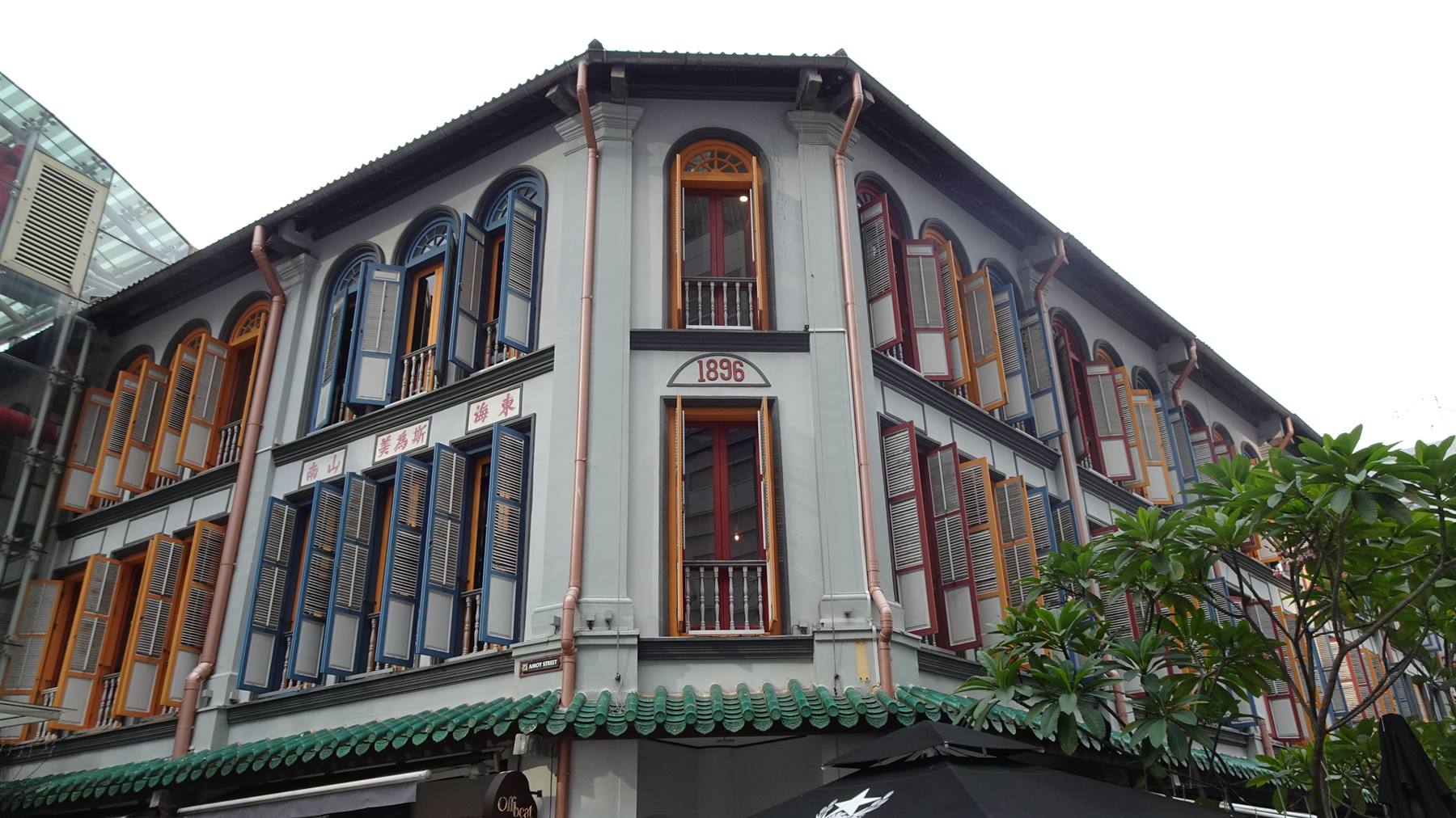 Palazzo coloniale grigio del 1896 con persiane colorate a Chinatown