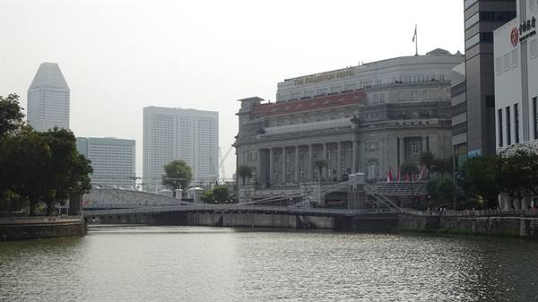 On the riverbank, Singapore blends history and skyscrapers under a soft light.