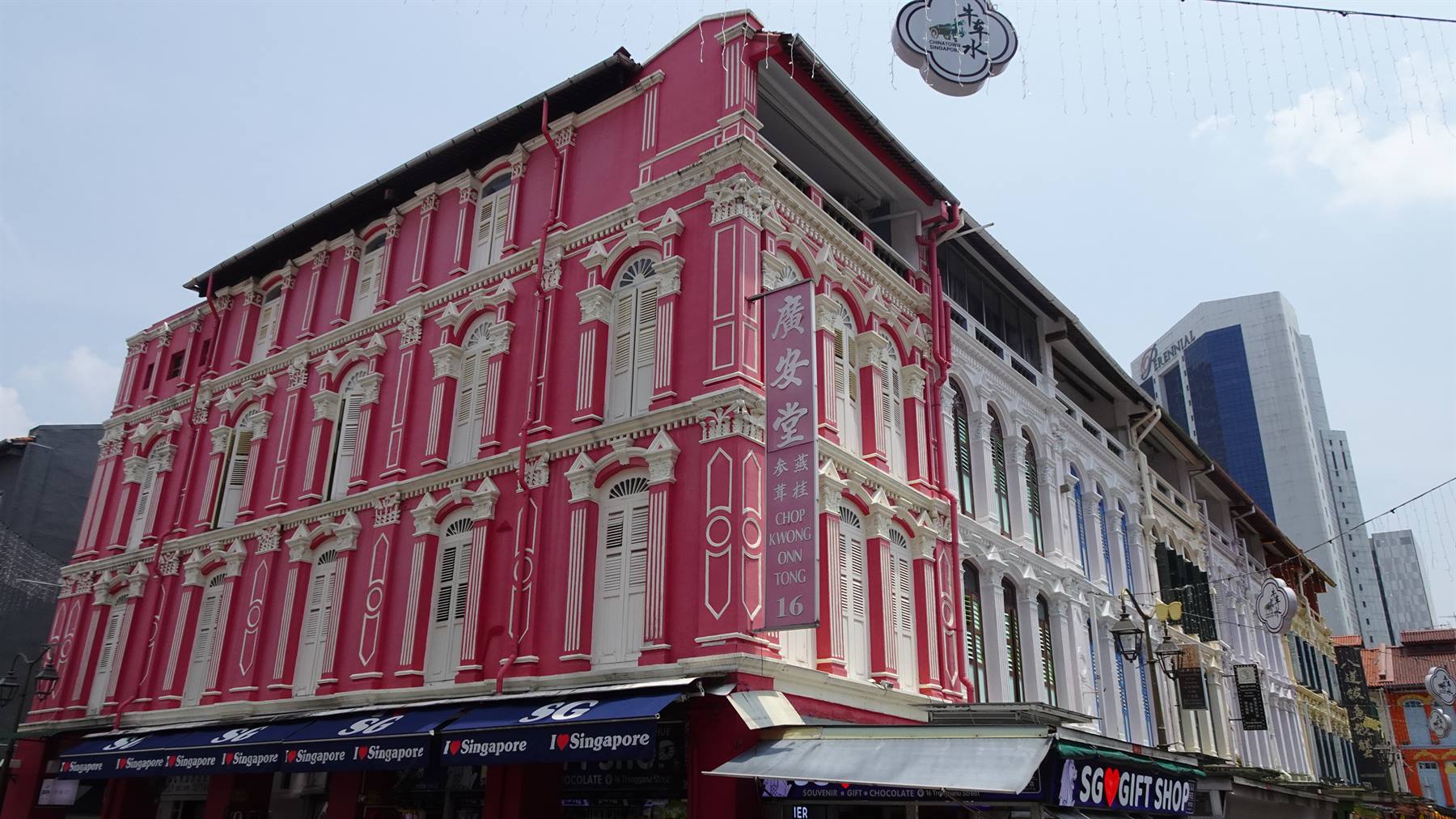 Negozio di souvenir sotto casa coloniale rosa e bianca a Chinatown, Singapore