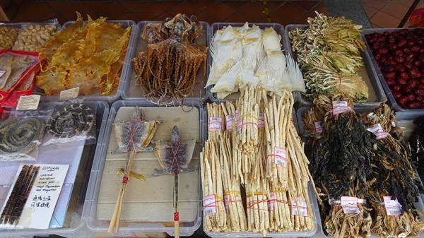 Plastic trays with dried seafood and seahorses at a market