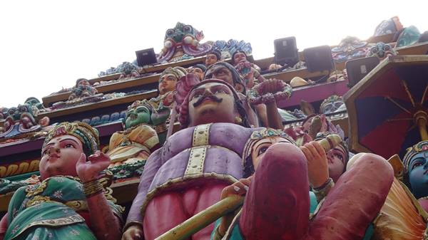 Painted Hindu deity statues on a temple gopuram tower