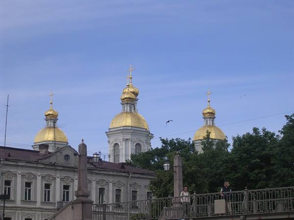 Golden domes of St. Nicholas Cathedral rise above a bridge in Saint Petersburg