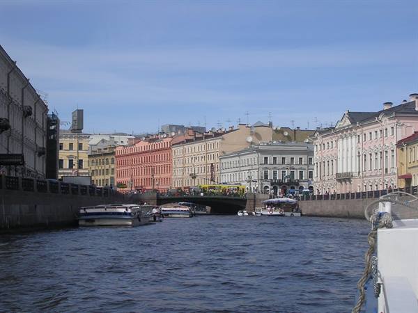 Boats on the Griboedov Canal among colorful buildings and a bridge, Saint Petersburg