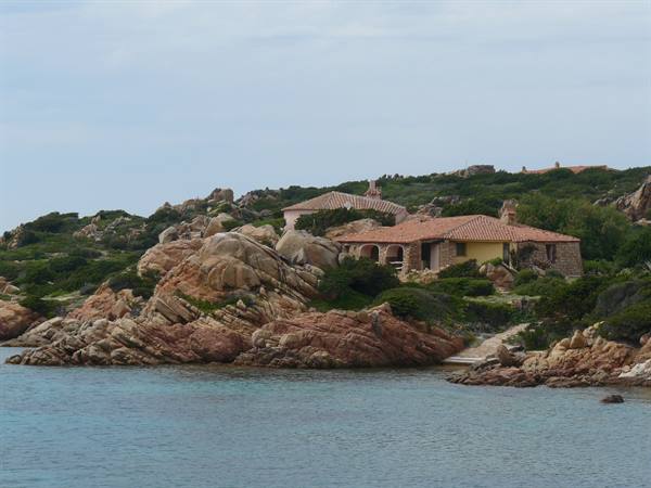 Stone houses with red-tiled roofs among pink granite rocks, Caprera