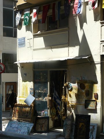 Antique shop with hanging flags, paintings and icons displayed on the sidewalk
