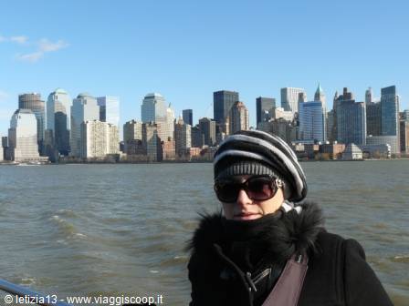 Woman in striped hat and sunglasses in front of Lower Manhattan skyscrapers