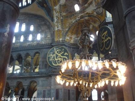 Glowing chandelier and Islamic calligraphy medallions inside Hagia Sophia