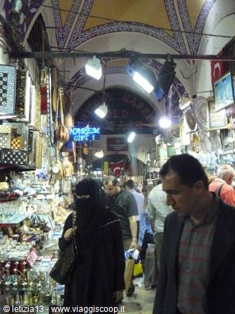 Women in niqab passing souvenir stalls inside Istanbul's covered bazaar