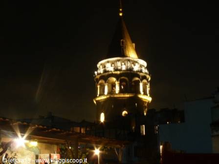Galata Tower lit up at night above Istanbul rooftops