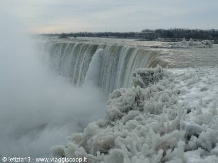 Frozen Niagara Falls, icy blocks in the foreground, mist rising from falling water