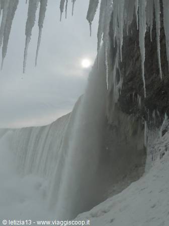 Frozen Niagara Falls, icicles hanging over the misty cascading water in winter