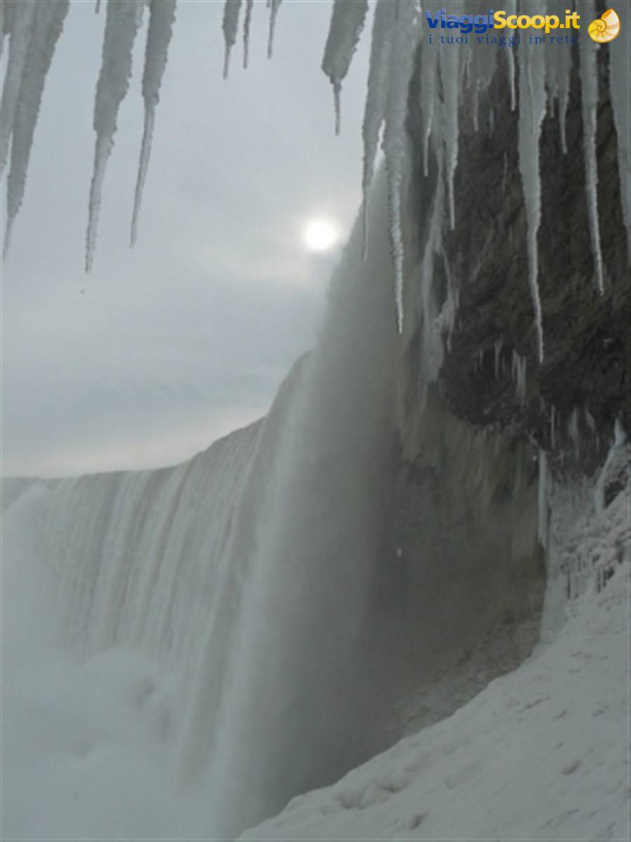Frozen Niagara Falls, icicles hanging over the misty cascading water in winter