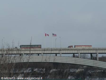 Trucks and Canadian and American flags on the border bridge