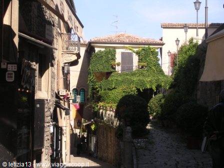 Cobbled uphill alley between ivy-covered houses, sunny daylight