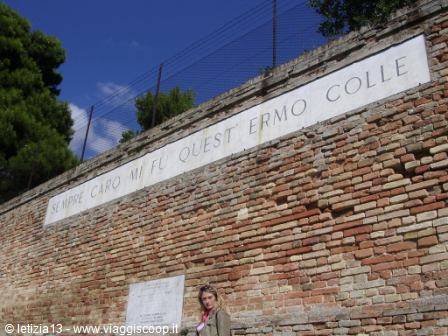 Woman by the brick wall bearing the inscription at Ermo Colle