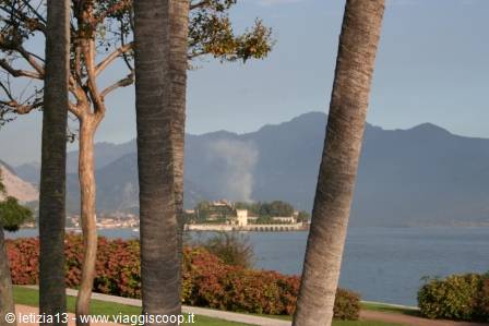 Palms and flowers frame Isola Bella on Lake Maggiore among misty mountains