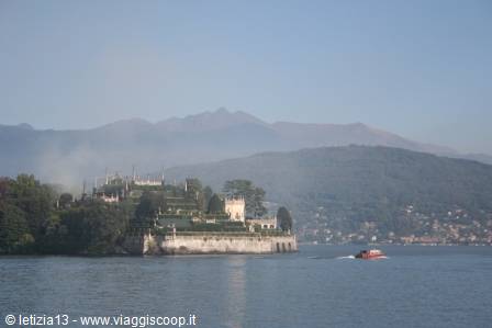 Isola Bella on Lake Maggiore, red boat crossing the calm waters