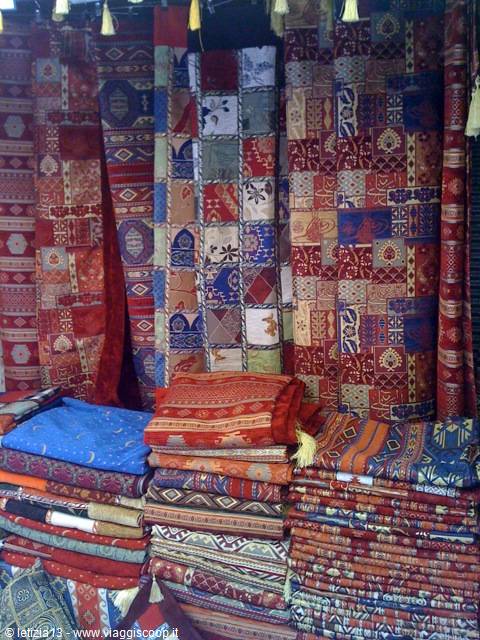 Colorful carpets and fabrics hanging and folded in a souk shop