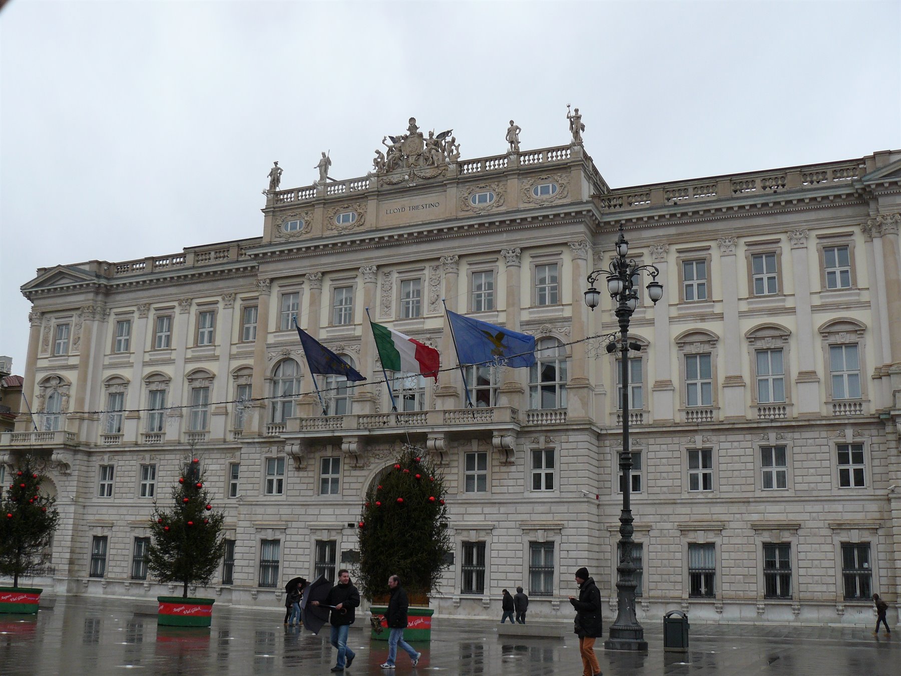 Palazzo del Governo in Piazza Unità d'Italia a Trieste, bandiere sventolano sotto il cielo grigio