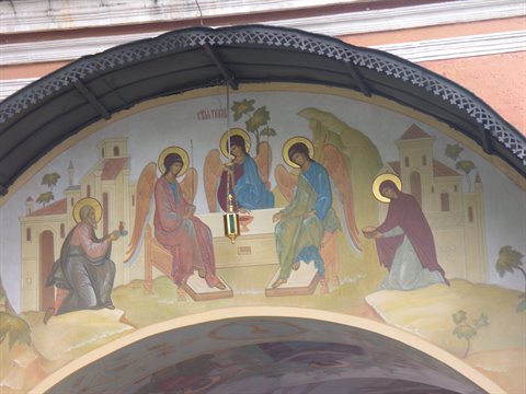 Trinity fresco with three angels at a table above a church entrance