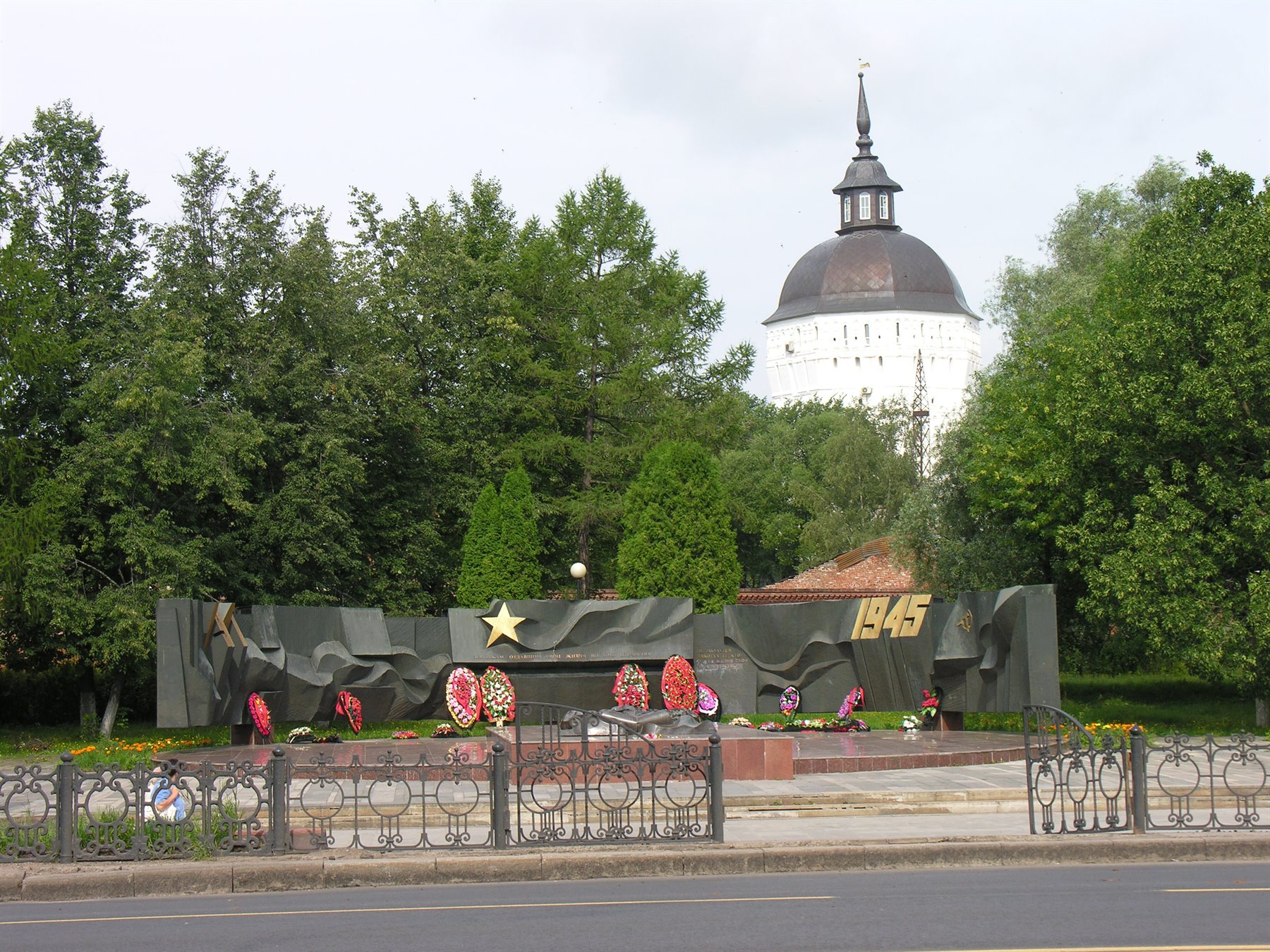Monumento militare con stella e corone di fiori, dietro la cattedrale bianca di Troickij a Serpuchov