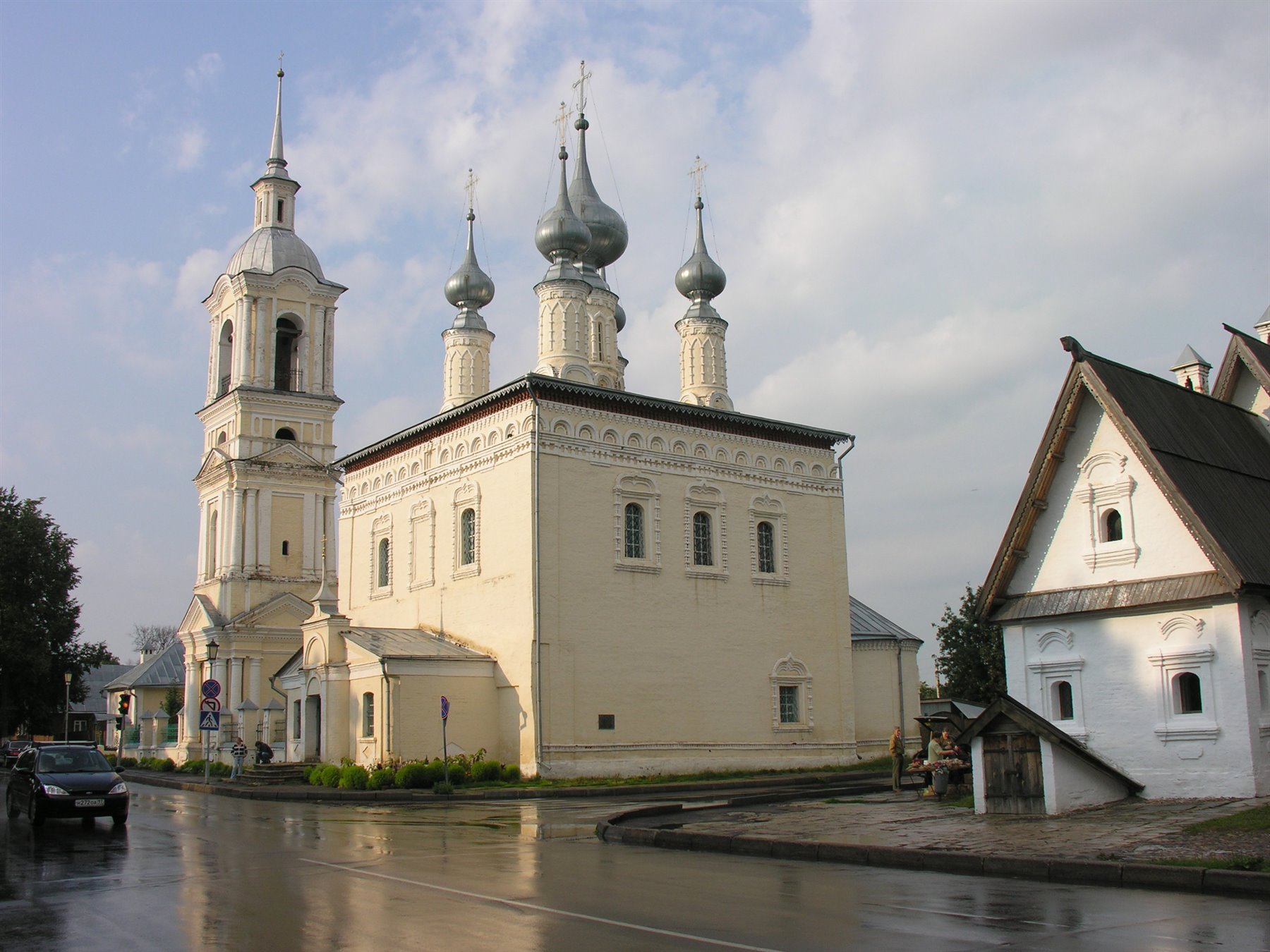 Chiesa bianca con cupole d'argento e campanile su strada bagnata, Suzdal